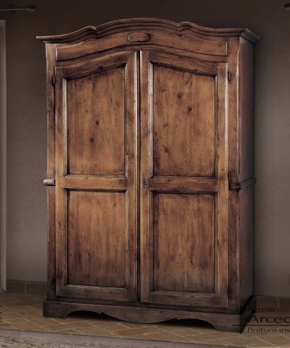 Armadio stile inglese con due ante e parte superiore sagomata a cappello di gendarme, interno con bastone appendi abiti e ripiano.