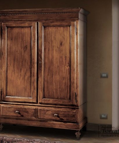Armadio a due ante con piedi a cipolla torniti, e due cassetti nella parte inferiore, costruito in legno massello invecchiato.