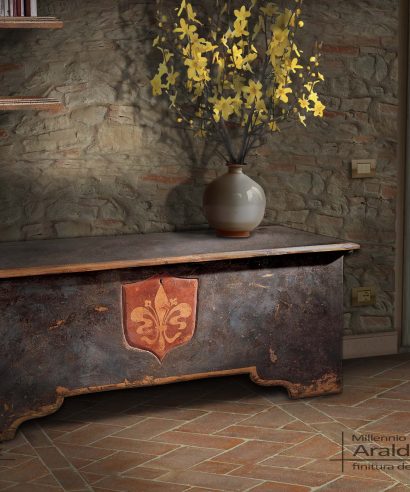 Un altra versione della cassapanca Araldo, questa con finitura calce antica blu petrolio e decorazione giglio Fiorentino sulla scudo intagliato a mano.