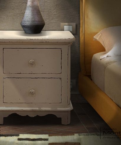 Comodino in legno laccato scrostato vintage, con due cassetti e angoli scantonati.