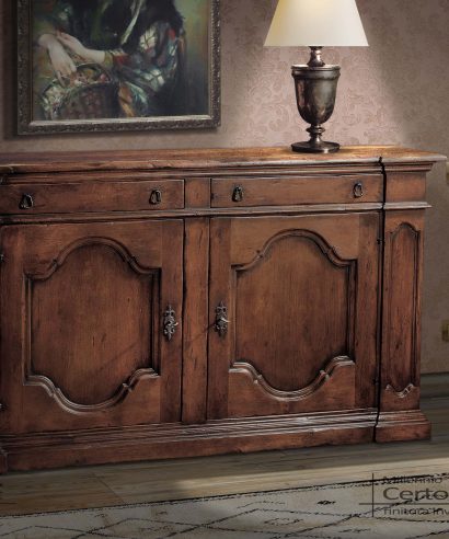 Credenza con due ante e due cassetti costruita in pioppo massello con finitura noce invecchiato.
