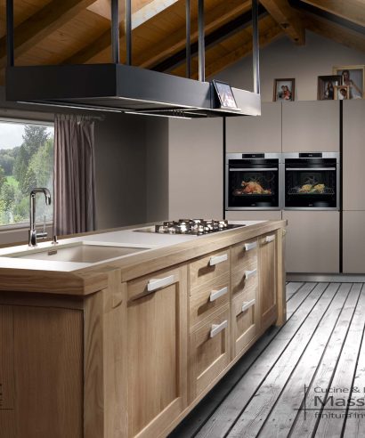 Cucina a isola con piano cottura e lavello, costruita in castagno naturale spazzolato e verniciato trasparente con vernice acrilica dall'effetto neutro.