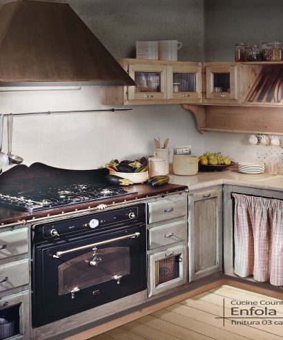 Cucina country in abete massello con finitura laccata vintage, piano in marmo Botticino e cappa in ferro ruggine.