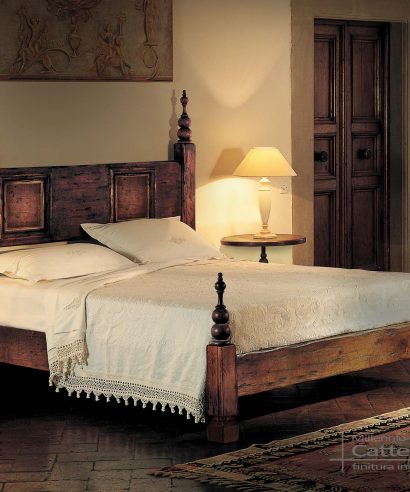 Letto matrimoniale per camera padronale, in legno massello con colonne su testata e pediera, e torniti a pinnacolo.