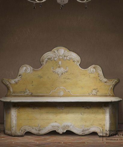 Cassapanca con coperchio di seduta apribile a contenitore, schienale a parete sagomato e base con angoli scantonati, decorazione artistica fatta a mano.