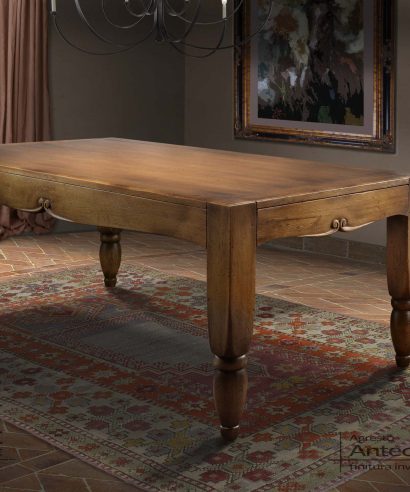 Tavolo da pranzo Anteo, rettangolare in legno massello con gambe di forte spessore e intaglio sulle fasce laterali.
