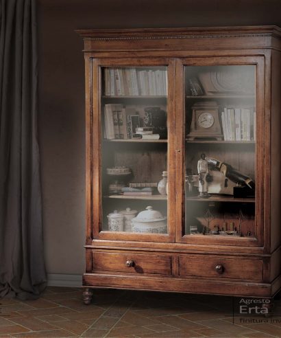 Vetrina in stile "800" con piedi a cipolla torniti e due ante a vetro, sotto le ante ci sono due cassetti con pomello in legno.
